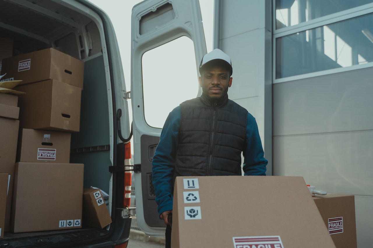 imagem de um homem negro descarregando caixas para entrega
