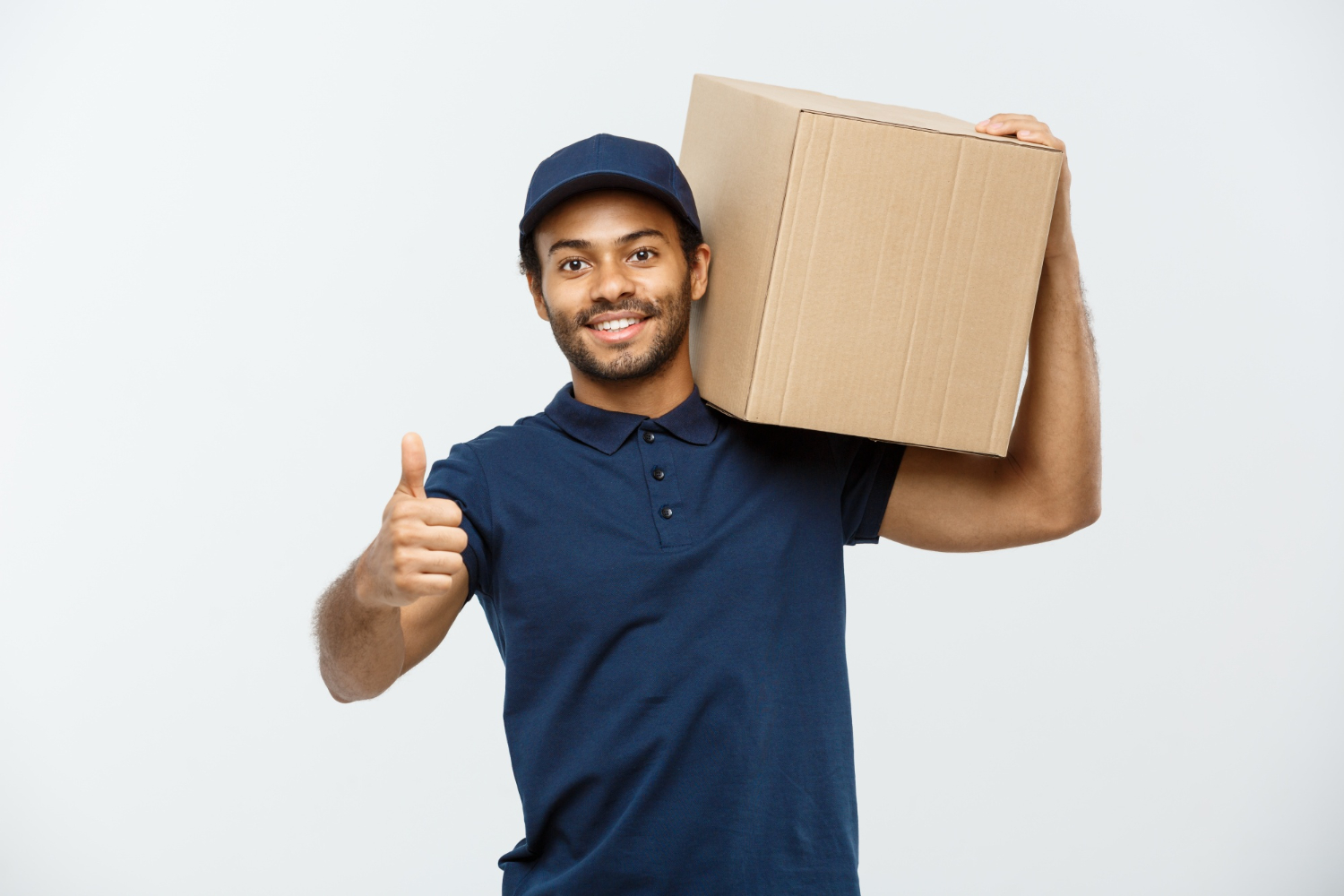 imagem de um entregador de camiseta e boné azul com uma caixa nos ombros e fazendo sinal de positivo com a mão